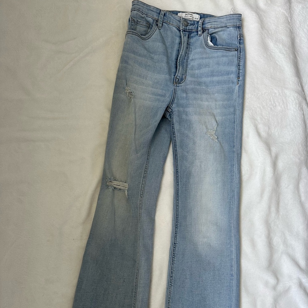 light blue jean pants with wide boots from Stradivarius brand